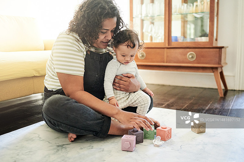 家中，母亲和宝宝在地板上玩积木，促进儿童发展图片素材