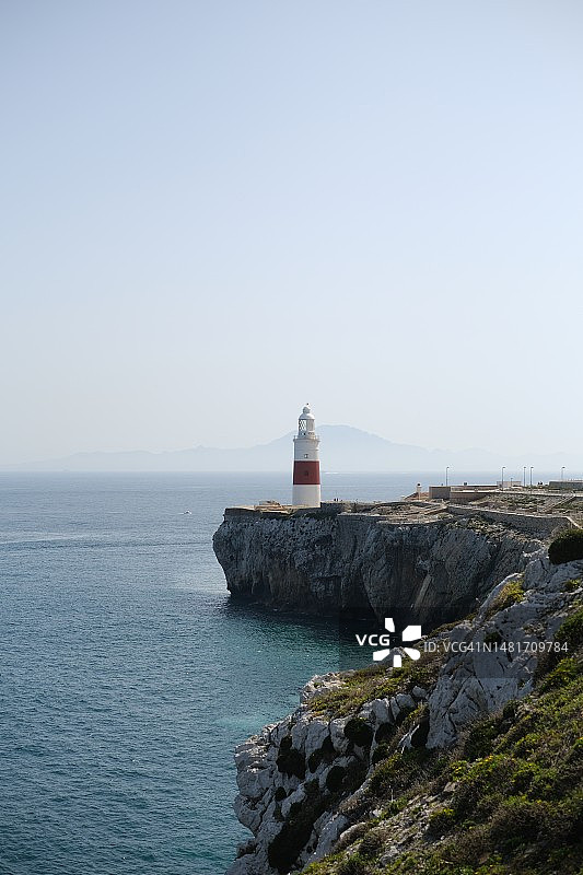 远处眺望海边悬崖上的灯塔图片素材