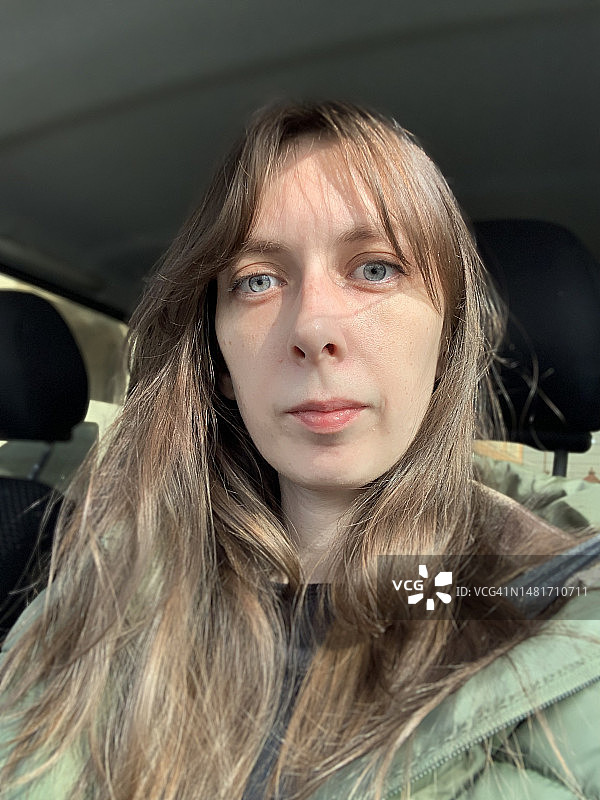 蓝眼睛棕色头发女孩在车内特写自拍图片素材