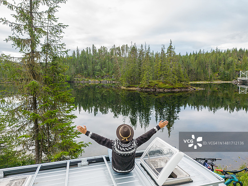 男子在面包车顶上看风景的无人机视角图片素材