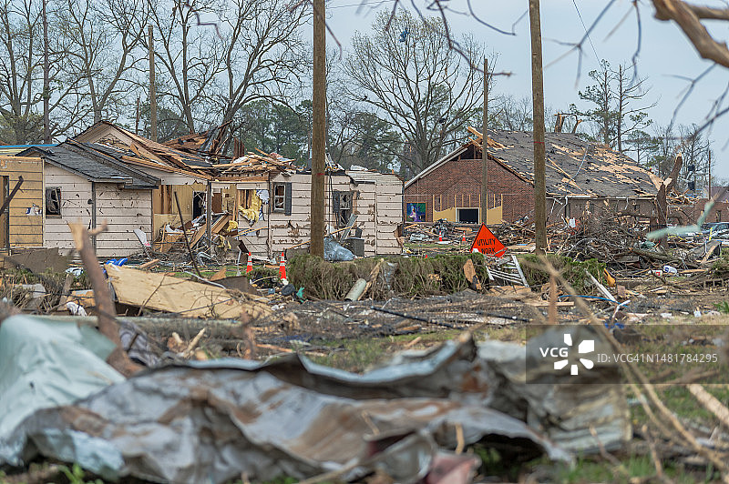 龙卷风过后，被毁房屋前的倒塌电线，散落着断枝、个人物品和碎片图片素材