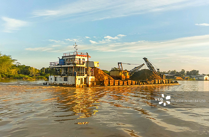 在马来西亚沙捞越阳光明媚的早晨，一艘平底船在拉让江上行驶图片素材