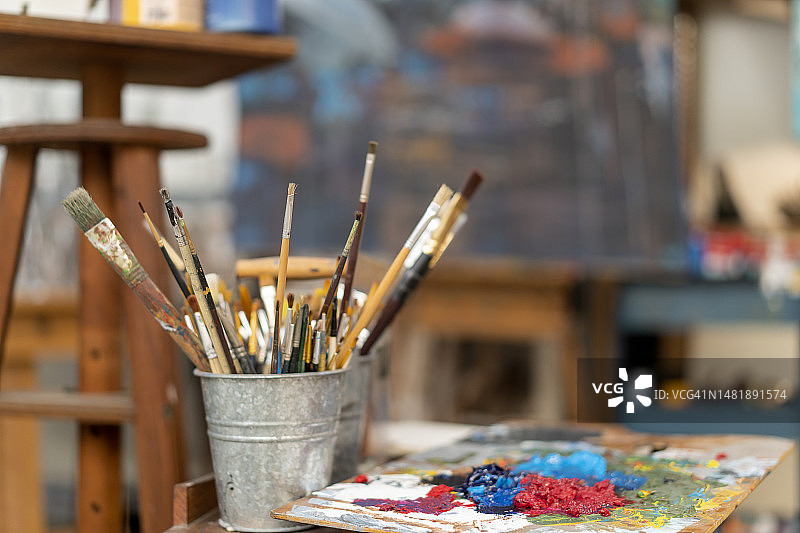 调色板上用过的画笔和彩色油画颜料图片素材