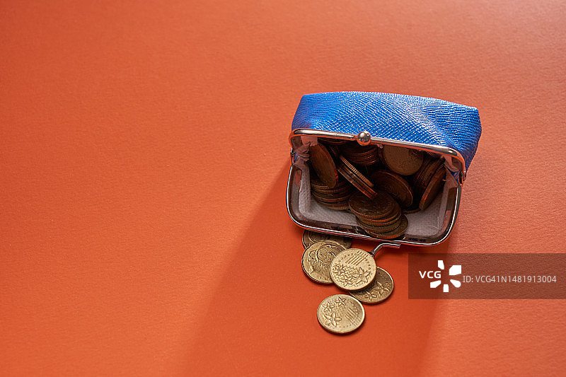 橙色背景下的蓝色硬币钱包，马来西亚图片素材