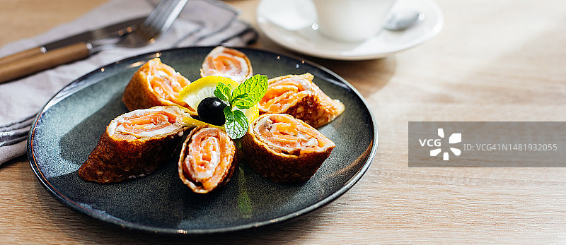 美味的薄煎饼配熏鲑鱼和奶油奶酪，浅色木桌上的早餐，罗马尼亚图片素材