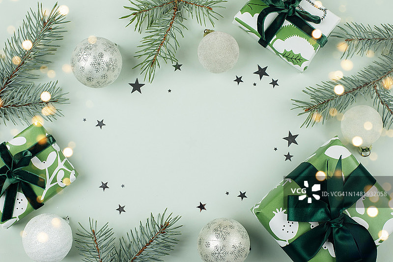 圣诞贺卡边框，饰有冷杉树、礼品盒和圣诞装饰，浅绿色背景，罗马尼亚图片素材