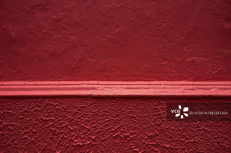 殖民时期建筑外墙，具有纹理灰泥和模制装饰，并涂有胭脂深红色图片素材