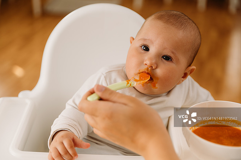 母亲在椅子上喂宝宝图片素材