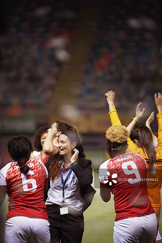 教练和她的足球队员们拥抱庆祝胜利图片素材