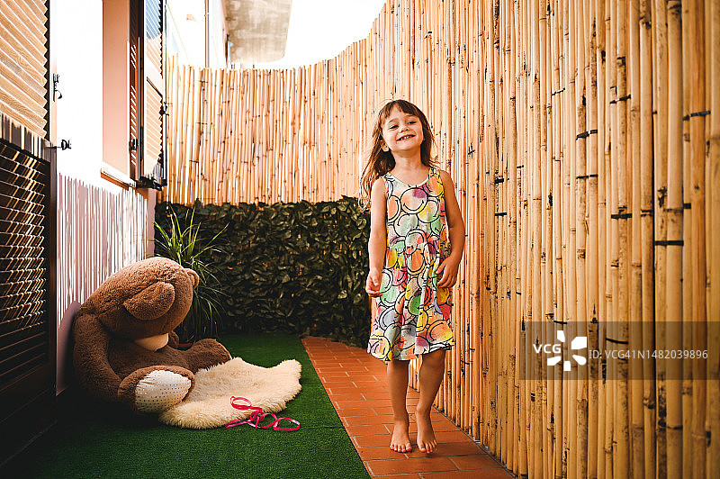 在自家露台上奔跑的微笑女孩图片素材