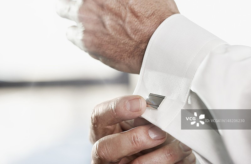 商人整理袖扣特写图片素材