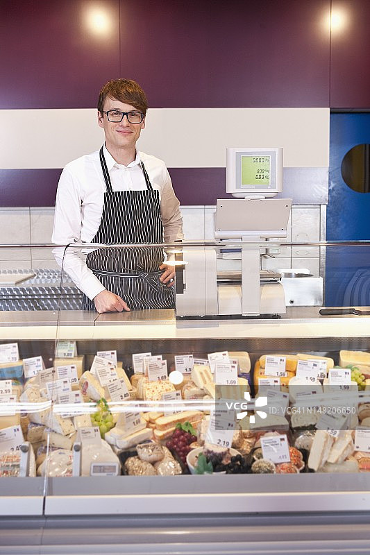 销售员站在奶酪店的柜台旁图片素材