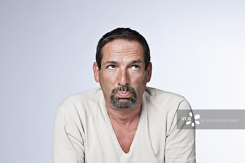 撅嘴的中年男子棚拍肖像图片素材