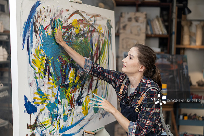 艺术家画家在她的创意工作室工作图片素材