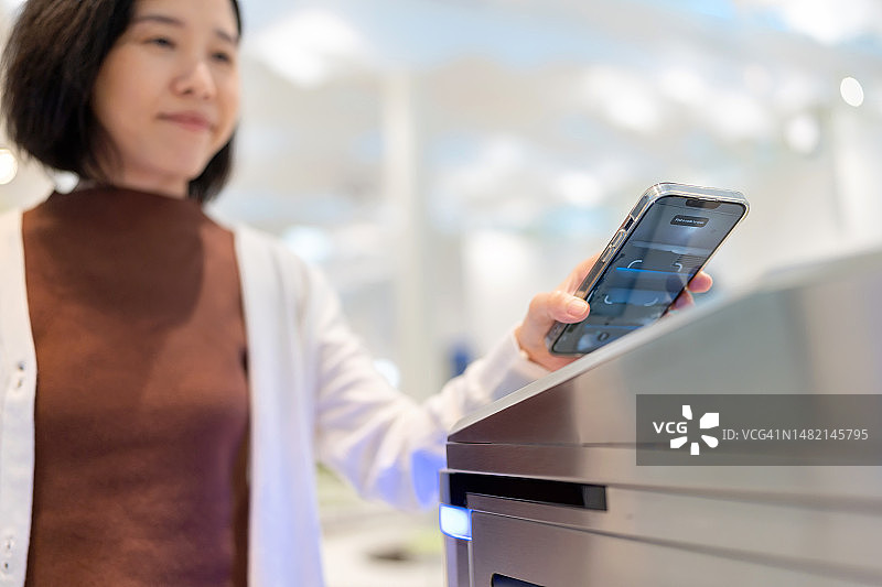 现代科技让您快速准确地获取信息。亚洲女商人在机场使用智能手机解锁图片素材