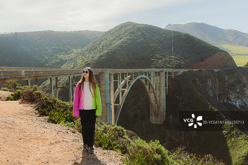女人背着背包探索加利福尼亚州比克斯比河大桥图片素材