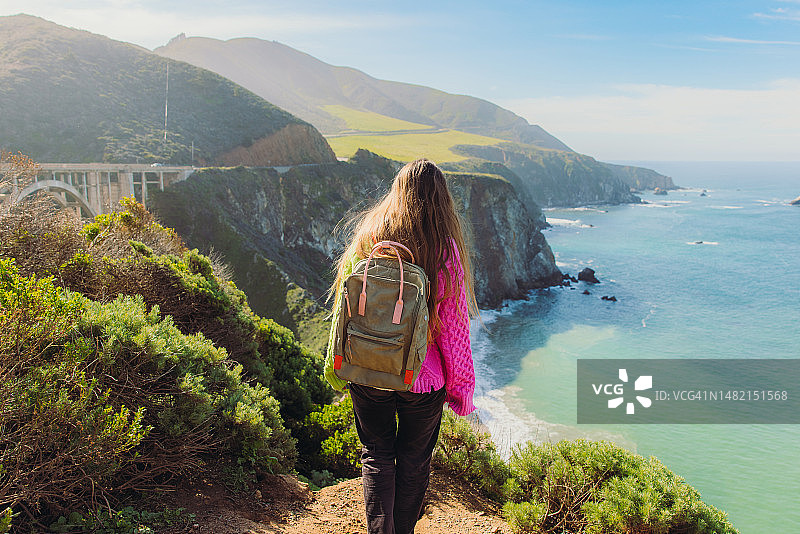 女人背着背包探索加利福尼亚州比克斯比河大桥图片素材