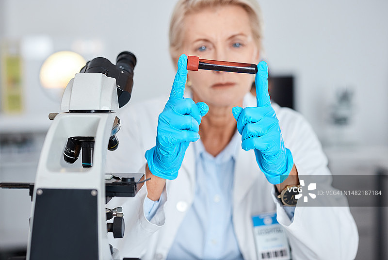老年妇女医生在实验室进行血液测试，用试管取样进行科学研究图片素材