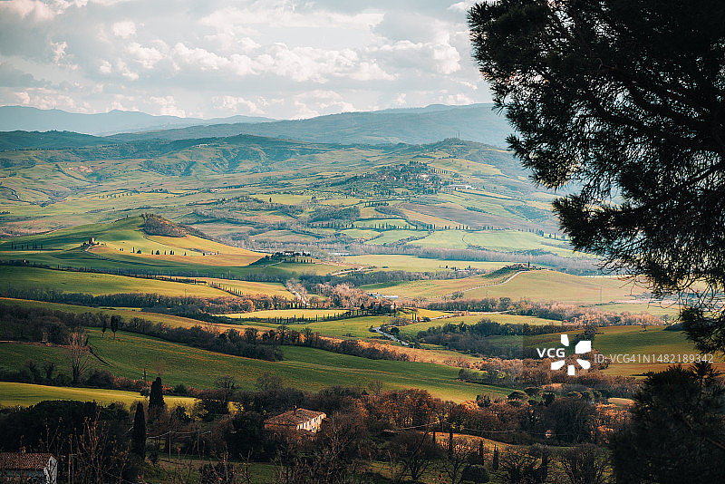 托斯卡纳午后春景：小路、绿色丘陵和柏树图片素材
