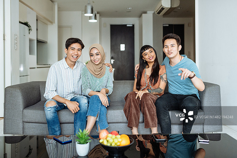 东南亚不同种族夫妇在沙发上看电视图片素材