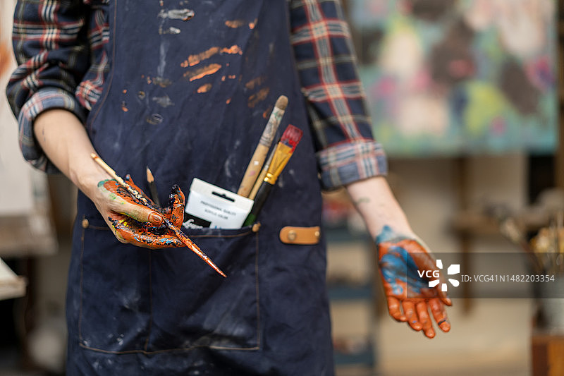 女艺术家手拿画笔和红色颜料图片素材