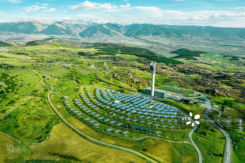 绿色环境中带有比利牛斯山脉的太阳能发电塔航拍图片素材