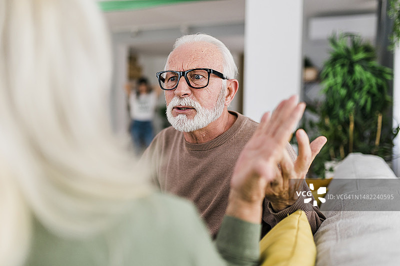 年长的异性夫妇在家里的沙发上争吵图片素材