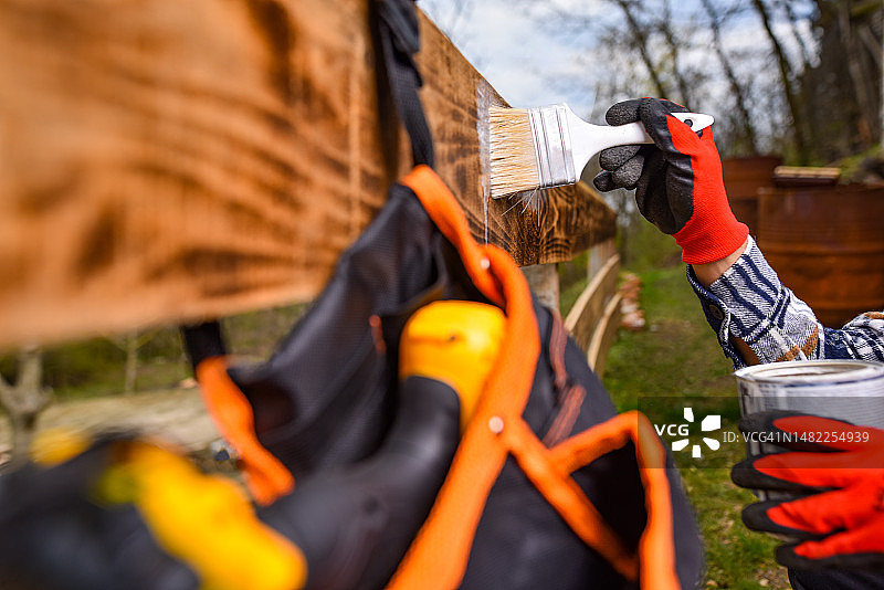木匠在木栅栏上涂白色油漆，有文字空间图片素材
