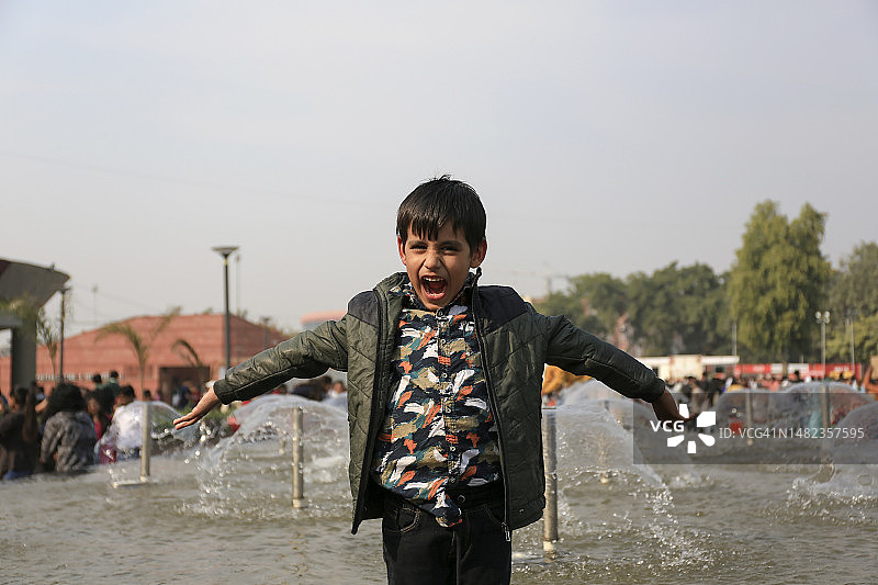 快乐的孩子站在喷泉附近图片素材