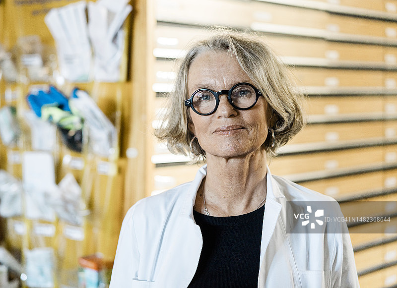 一个自信的老年女药剂师在医疗商店工作的肖像图片素材