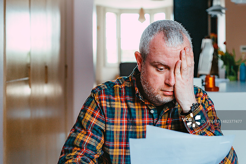 忧虑的男人在家查看账单图片素材