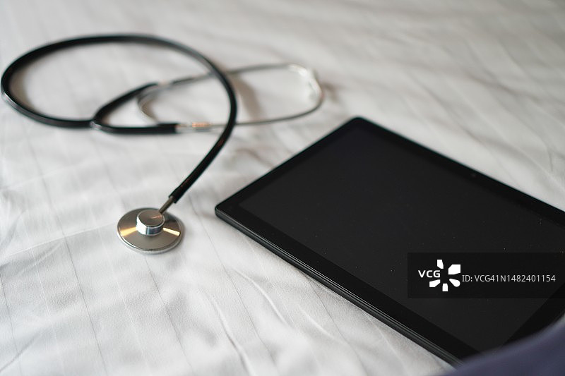 白色织物上的听诊器和平板电脑图片素材