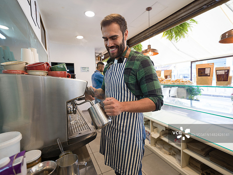 快乐的咖啡师在咖啡馆做咖啡图片素材