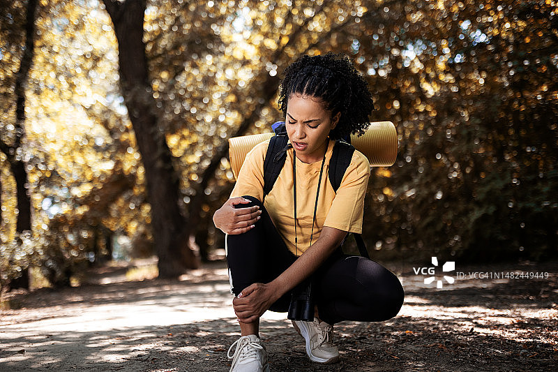 年轻女人在徒步旅行中受伤图片素材