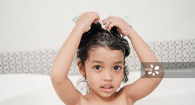 亚洲女童在浴室里洗头图片素材