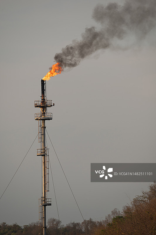 日出时炼油厂排放的烟雾，环境污染危机概念图片素材