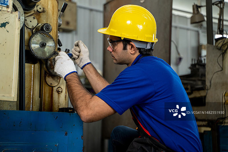 工业工程师穿安全服操作车床磨床。图片素材