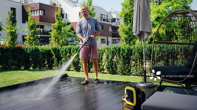 男人用高压清洗机清洁阳台图片素材