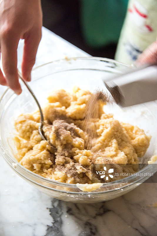 将酵母倒入装有蛋糕生面的碗中图片素材