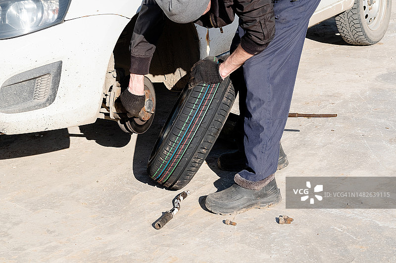 男人用套筒扳手给汽车换轮胎图片素材