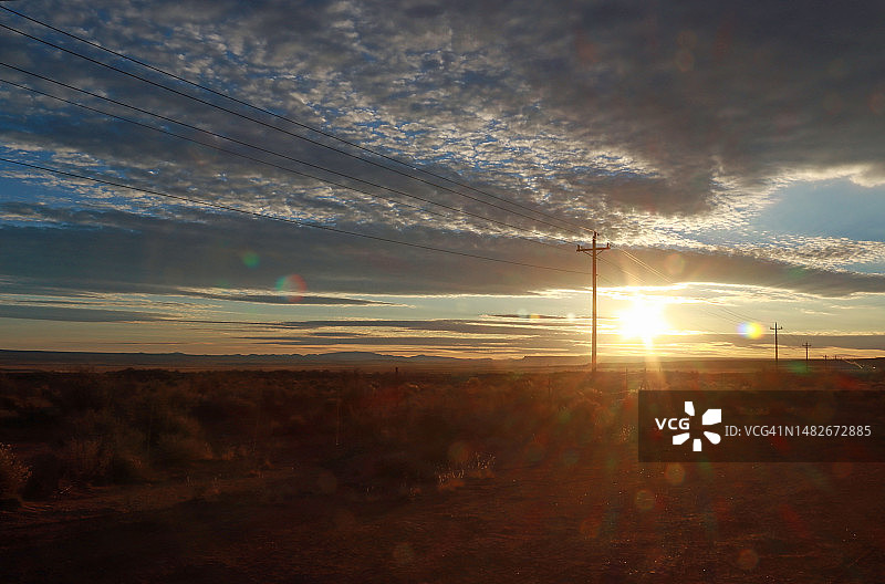 电线杆和电线及壮观云景后的日落图片素材