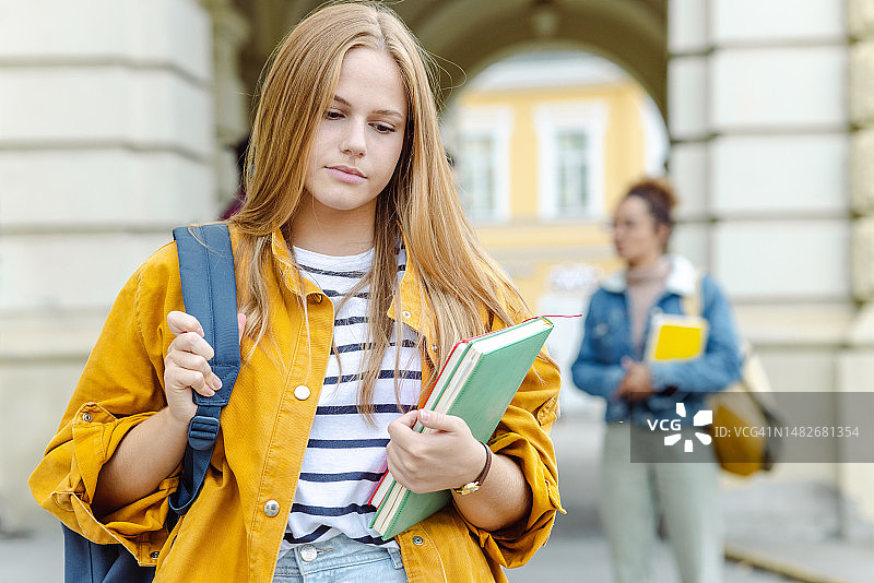 担忧的女学生走路带着书图片素材