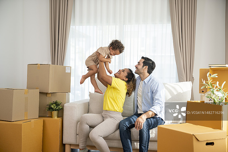 搬家日，父母和儿子在沙发上放松图片素材