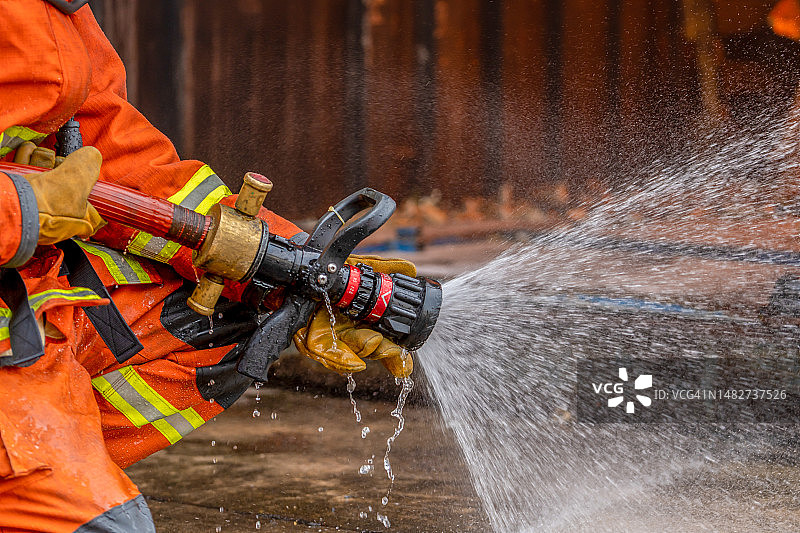 消防员在户外 holding 消防水带图片素材