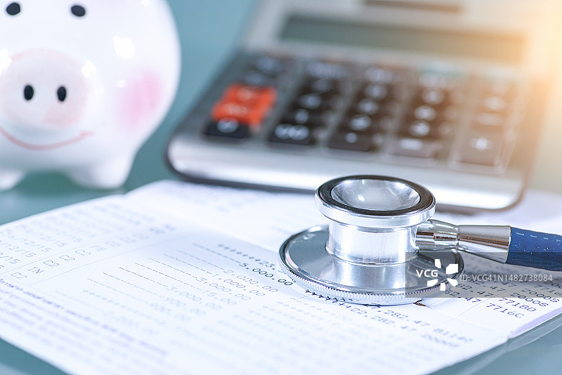 听诊器、计算器和小猪储蓄罐：医疗保健成本或医疗保险图片素材