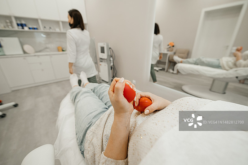 在美容院拿着抗压球的中年妇女图片素材