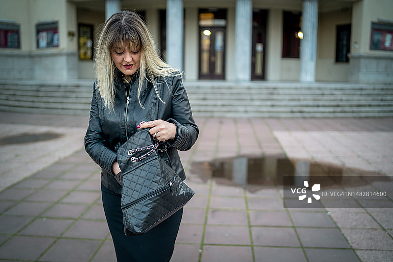 在街上翻包寻物的女人图片素材