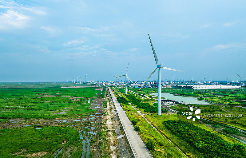 江苏省南通市，草原上的风力涡轮机，远处是村庄图片素材