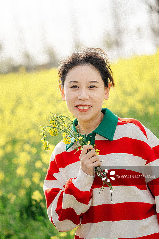 女孩手拿油菜花图片素材