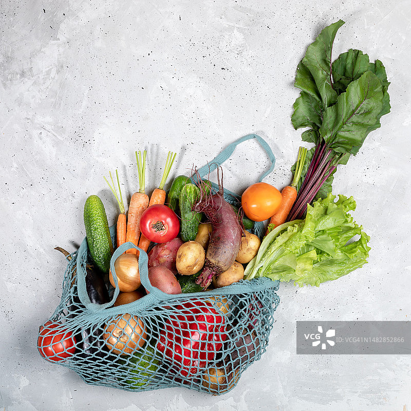 罗马尼亚灰色水泥背景上的新鲜农场蔬菜网兜俯视图图片素材